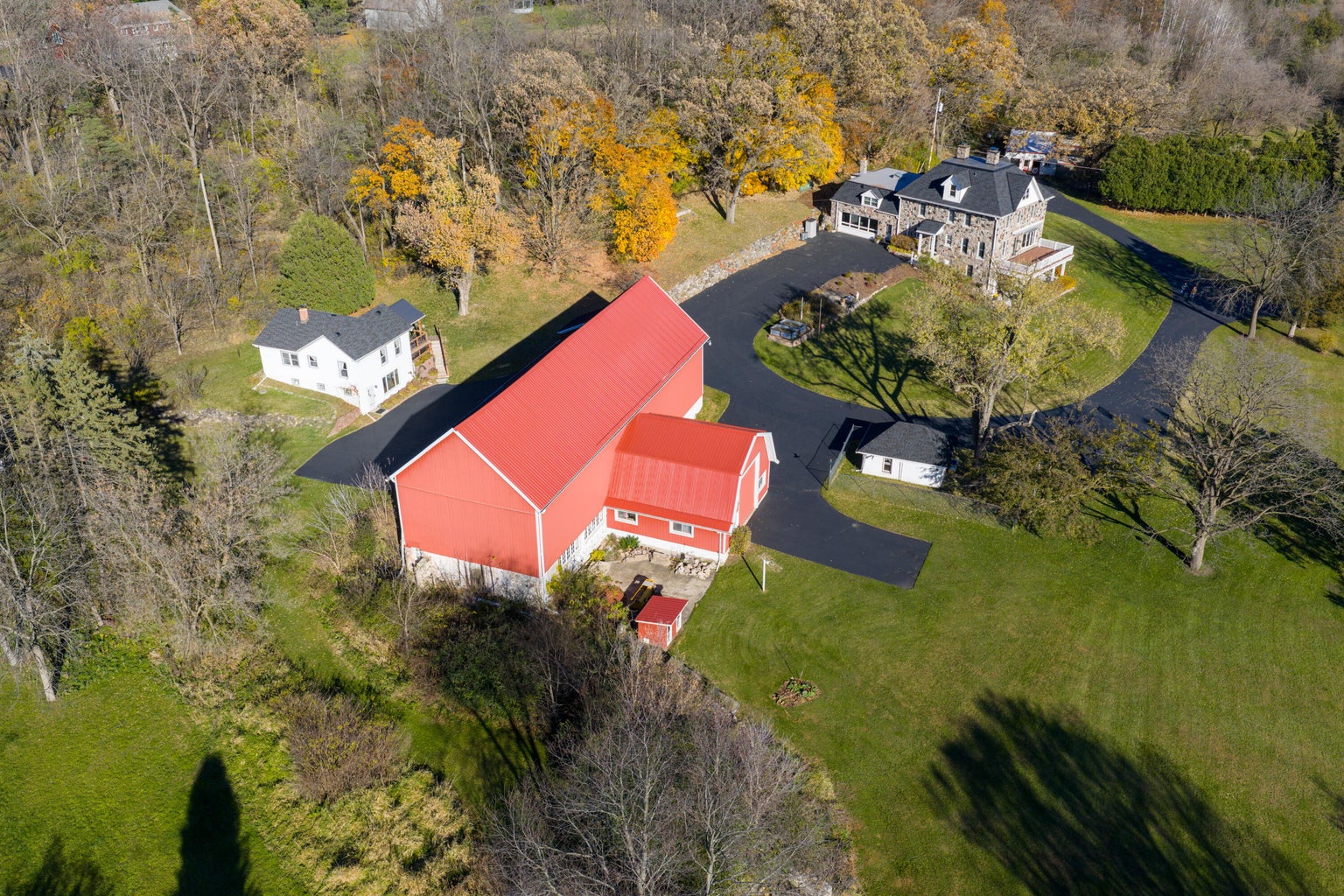 Aerial view of the historic 1885 Stonebrook Estate
                    farmstead, main stone house with red barn and
                    guest house on 7.08 acres along Scuppernong Creek,
                    Delafield Wisconsin